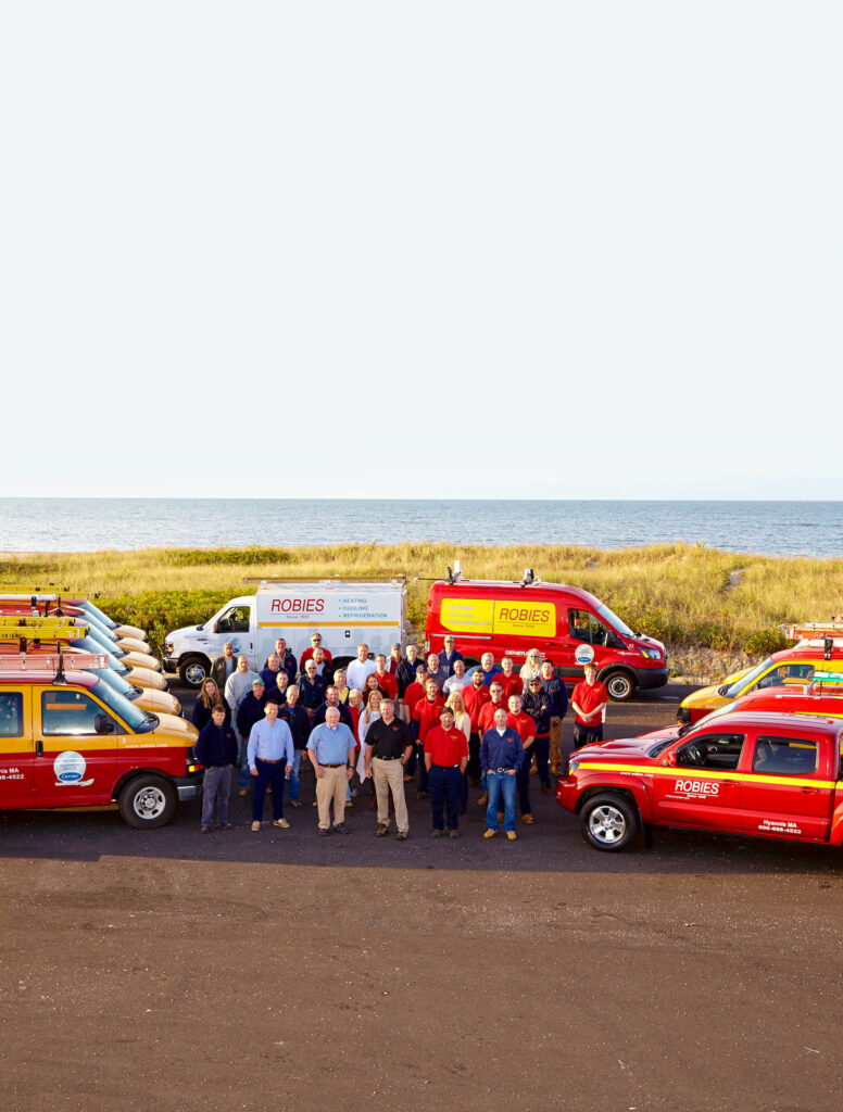 Group photo of Robies HVAC technicians, sales people and office staff at the beach in Hyannis.