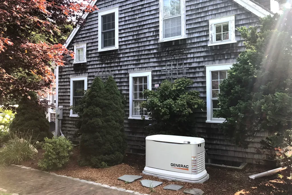 A Generac generator installed outside a home on Cape Cod by Robies keeps the power on during a power outage