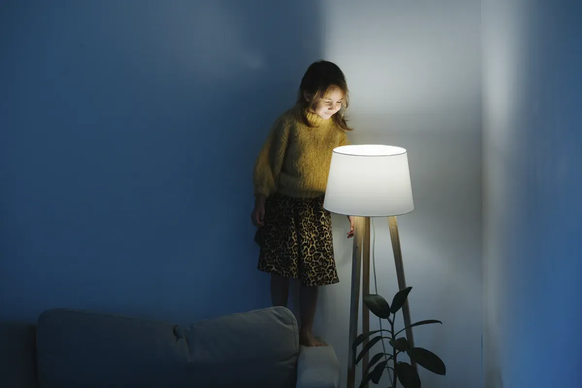 A girl staring down at a lamp